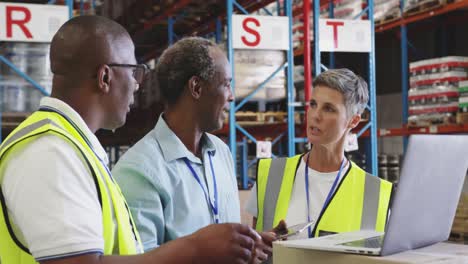 warehouse staff meeting around a laptop 4k