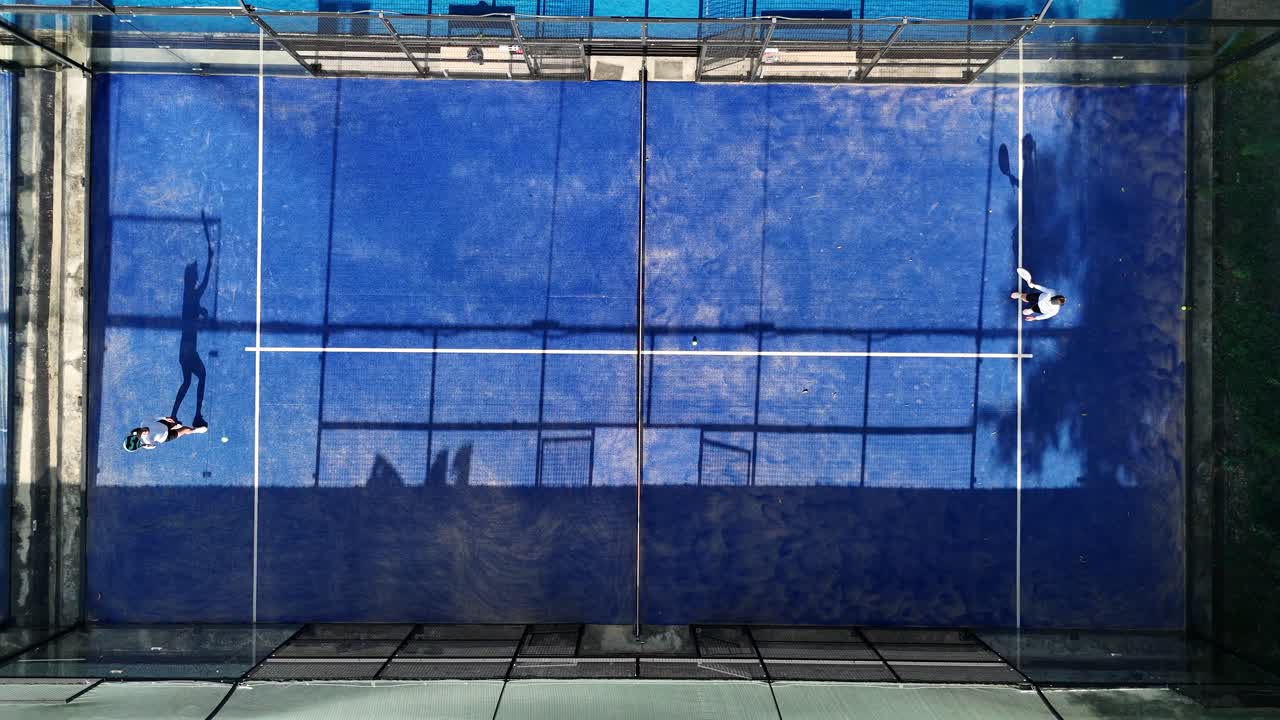 Aerial view of people playing padel on a blue court