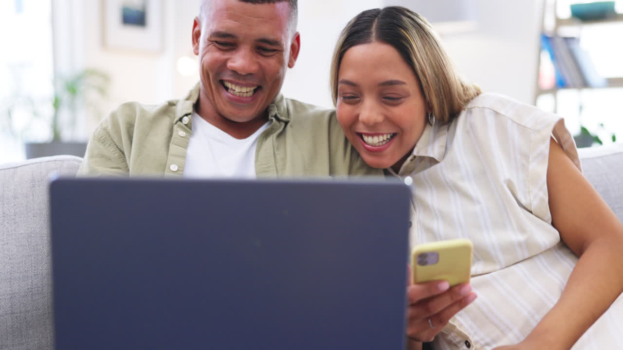 portátil, teléfono y pareja divertida en la sala de estar de la casa