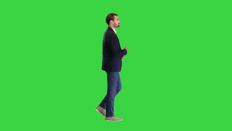 young handsome business man walking and talking to himself on a green screen, chroma key