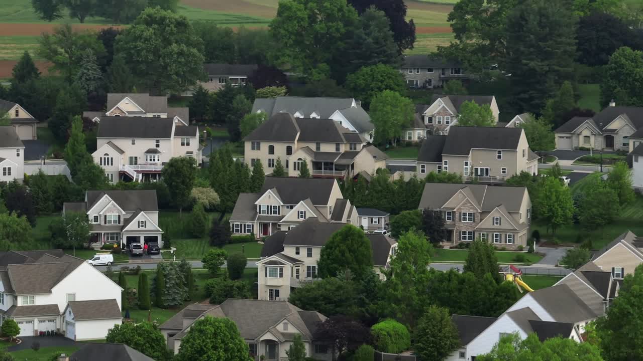 Aerial view of modern american suburb with large two-story homes, gabled roofs, garages and manicured yards. Classic east coast residential Architecture in United states. Wide shot.