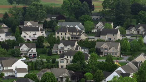 aerial view of modern american suburb with large two-story homes, gabled roofs, garages and manicured yards. classic east coast residential architecture in united states. wide shot.