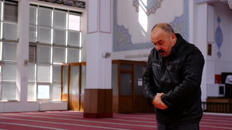 older man prays in mosque 1