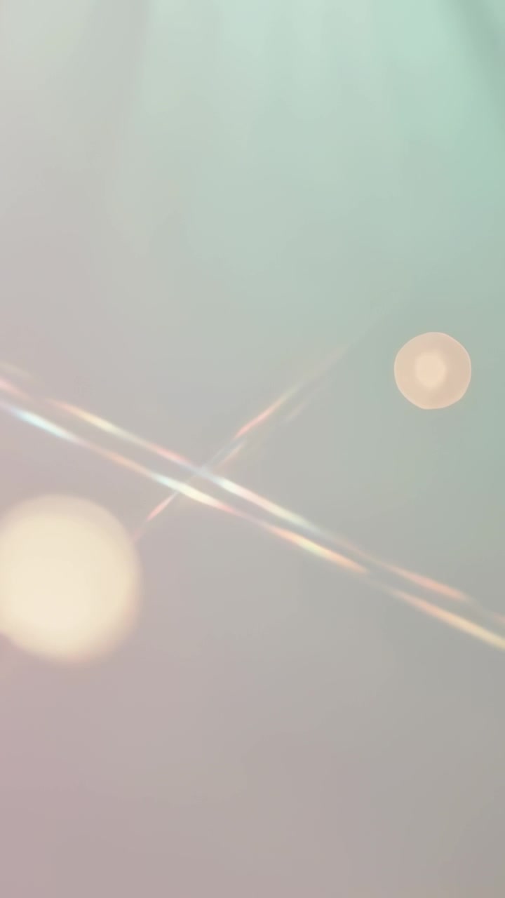 Vertical video: Emerging lights, diagonal streaks sliding across teal pink fade forming bokeh art