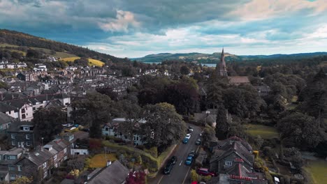 aerial footage of the quite village town of ambleside showing st mary’s church and lake windermere in the distance