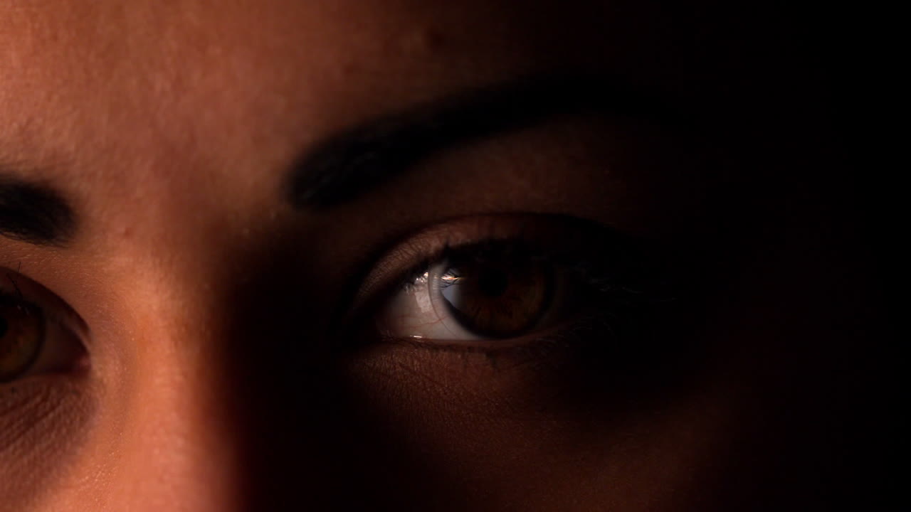 Mujer morena parpadeando sobre fondo negro