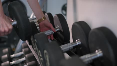 Person Handling Dumbbells in a Gym
