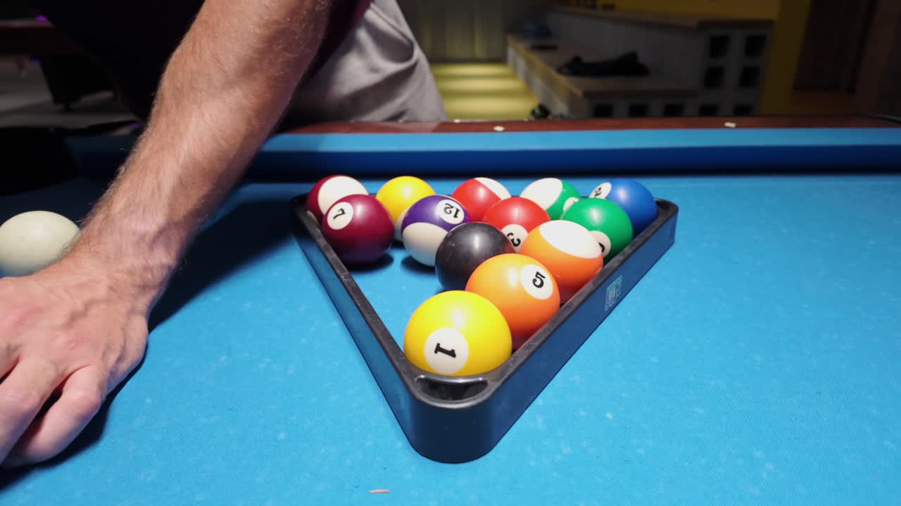 Person Setting Up Pool Balls on a Pool Table