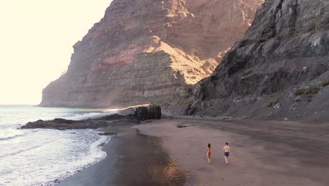 Idyllic-scene-of-two-people-at-unspoiled-virgin-beach-in-Gran-Canaria,-Spain-during-summer-time-on-vacations