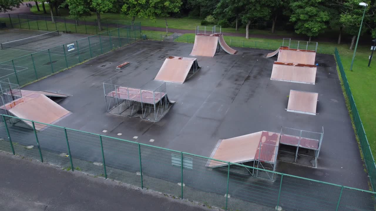 비어 있는 폐쇄된 공공 운동장에서 울타리가 있는 스케이트 공원 경사로 위를 날아가는 공중 전망
