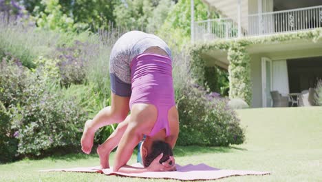 Glückliche-Biracial-Frau,-Die-Yoga-Im-Garten-Macht,-In-Zeitlupe