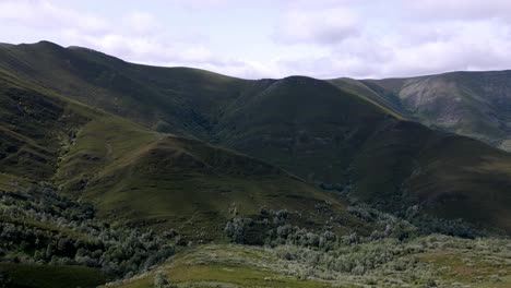 Imágenes-Aéreas-De-Drones-Mirando-Hacia-Un-Valle-En-Una-Exuberante-Cadena-Montañosa