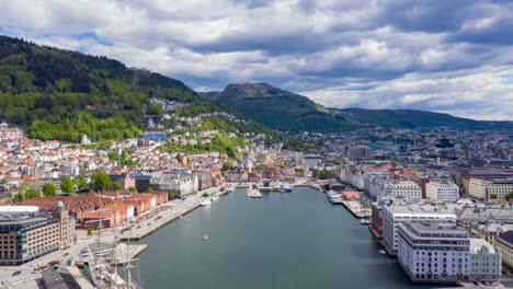 drone hyperlapse showing the famous landmark bryggen in bergen with boats, traffic and moving clouds