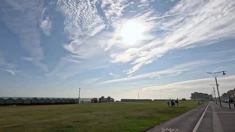 people walking under a bright, cloudy sky