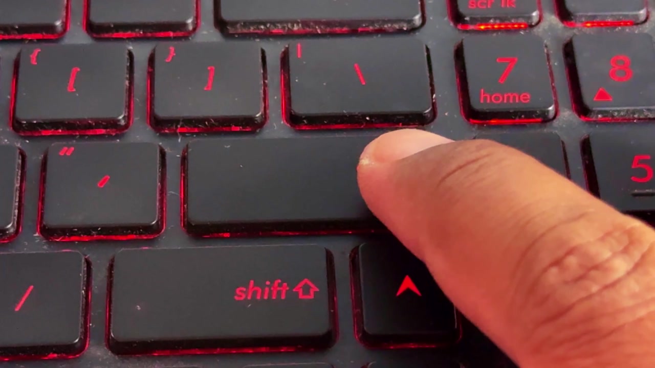 Finger hitting "enter" keyboard key, computer input action, technology and communication concept, macro detail.