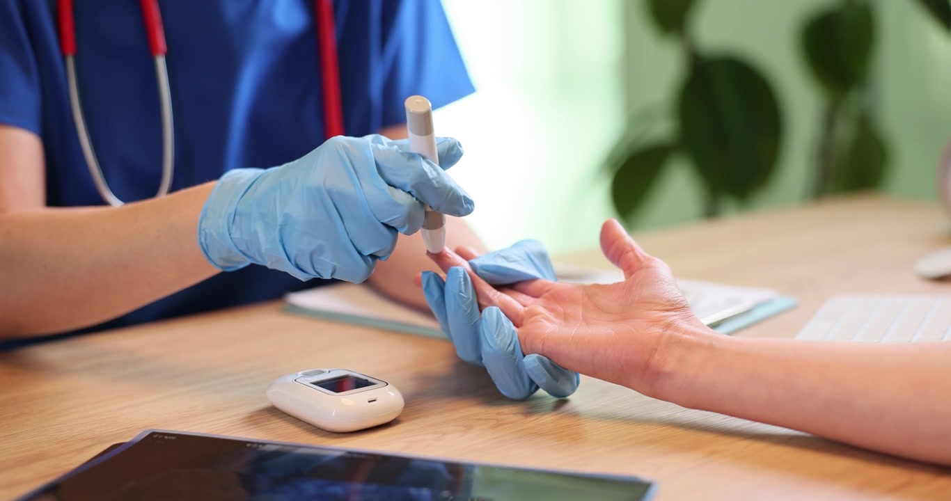 Doctor in gloves uses glucometer to check patient sugar in blood