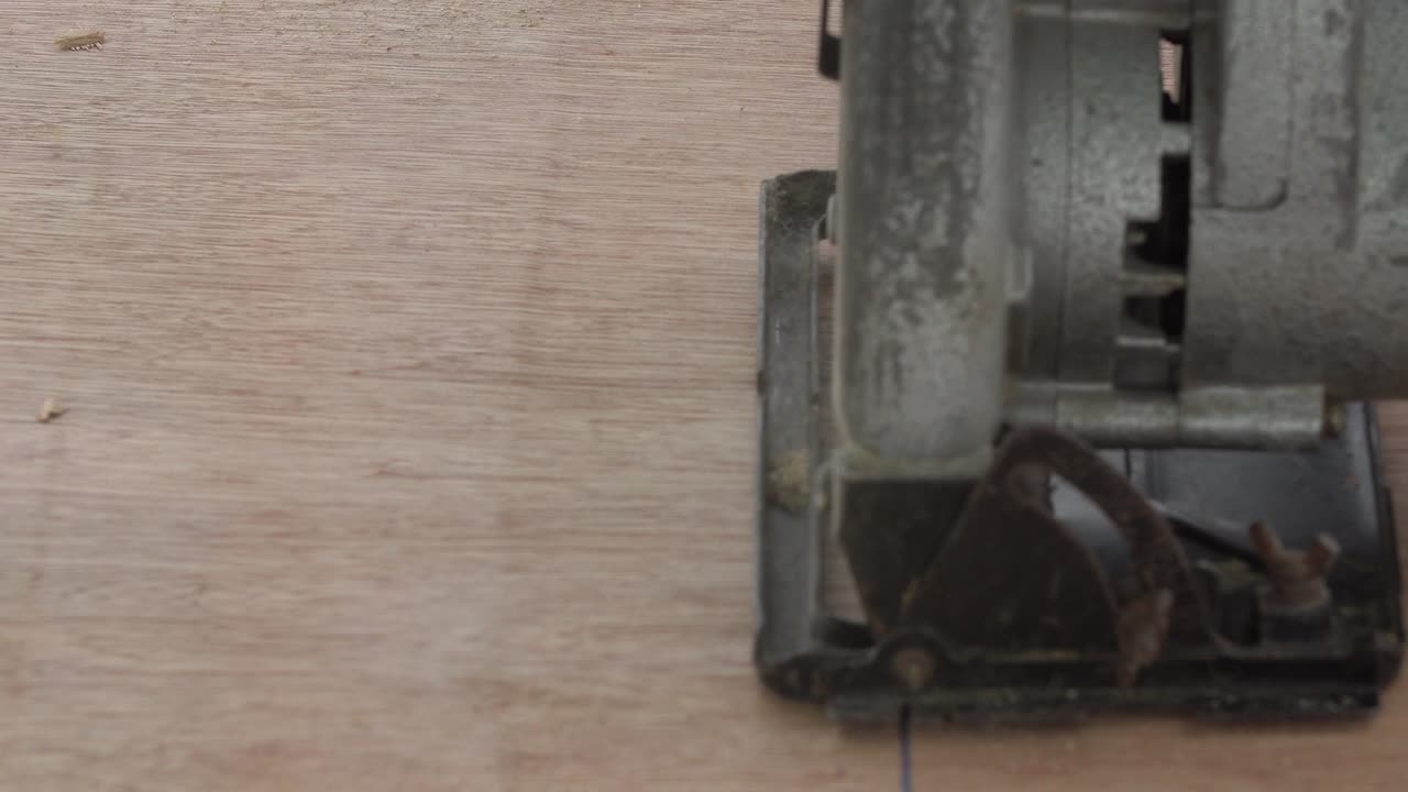 건축 노동자 들 이 야외 에서 원형 전기  을 사용 하여 나무판 을 자르고 있다