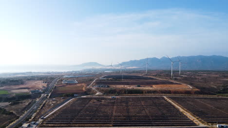 wind turbine farm and many solar panels in flat landscape of vietnam, aerial view