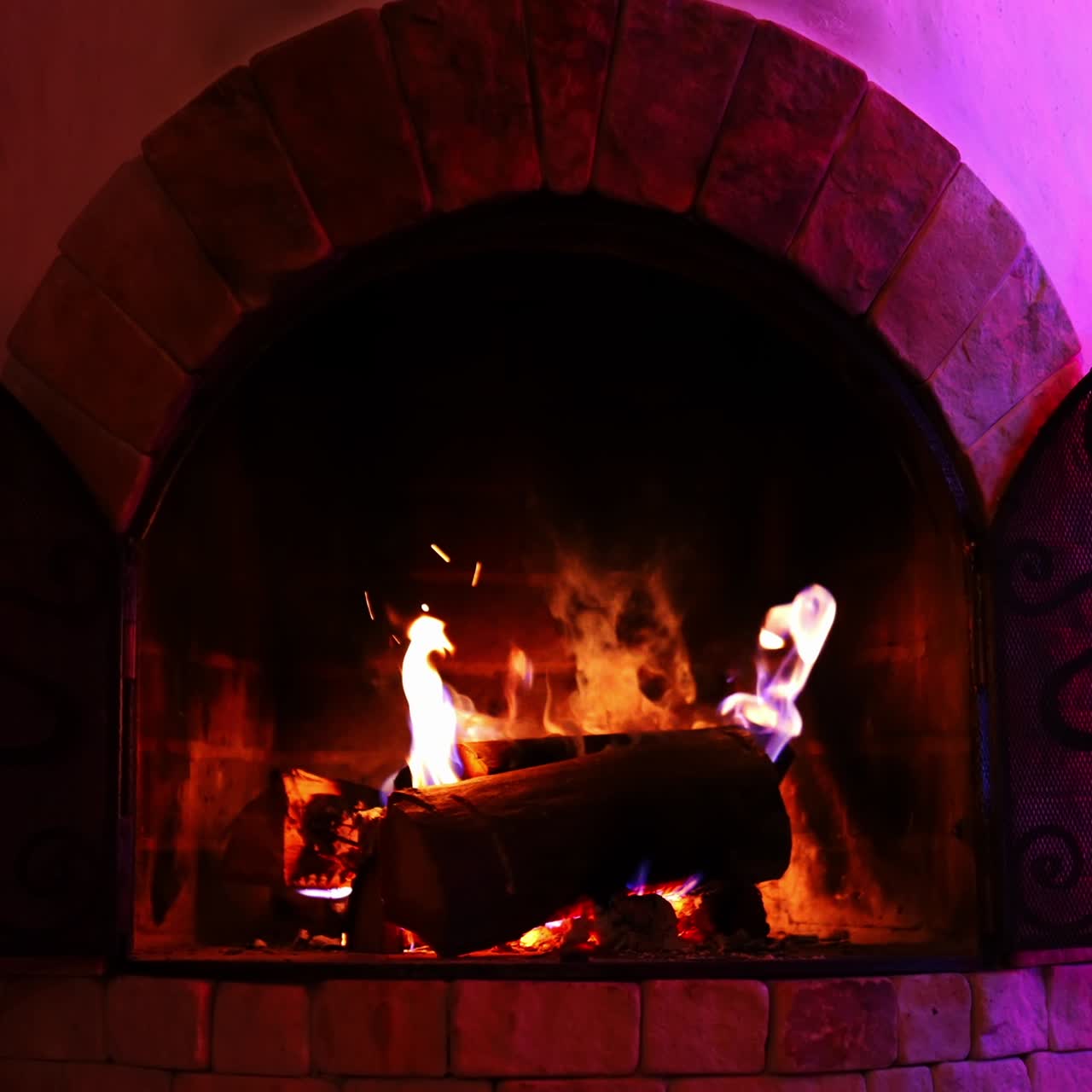 Wooden logs burning in fireplace. Beautiful brick fireplace with modern design. Cosiness and comfort at home in winter