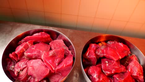 large bowls with cut beef meat on table in plant workshop