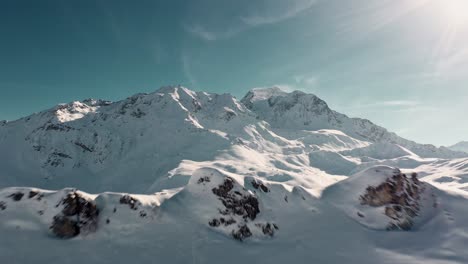 Antena:-Hermoso-Paisaje-De-La-Estación-De-Esquí-De-Les-Arcs,-Revelado-Detrás-De-La-Cima-De-La-Montaña-Nevada