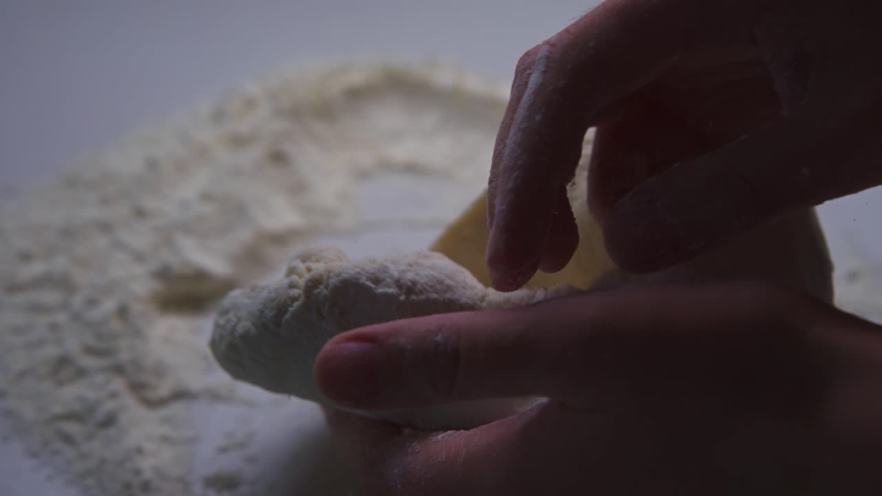 Close-Up of Hands Kneading Dough with Flour on a Table