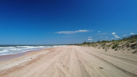 playa vacía contra el telón de fondo de cielo azul y mar salvaje