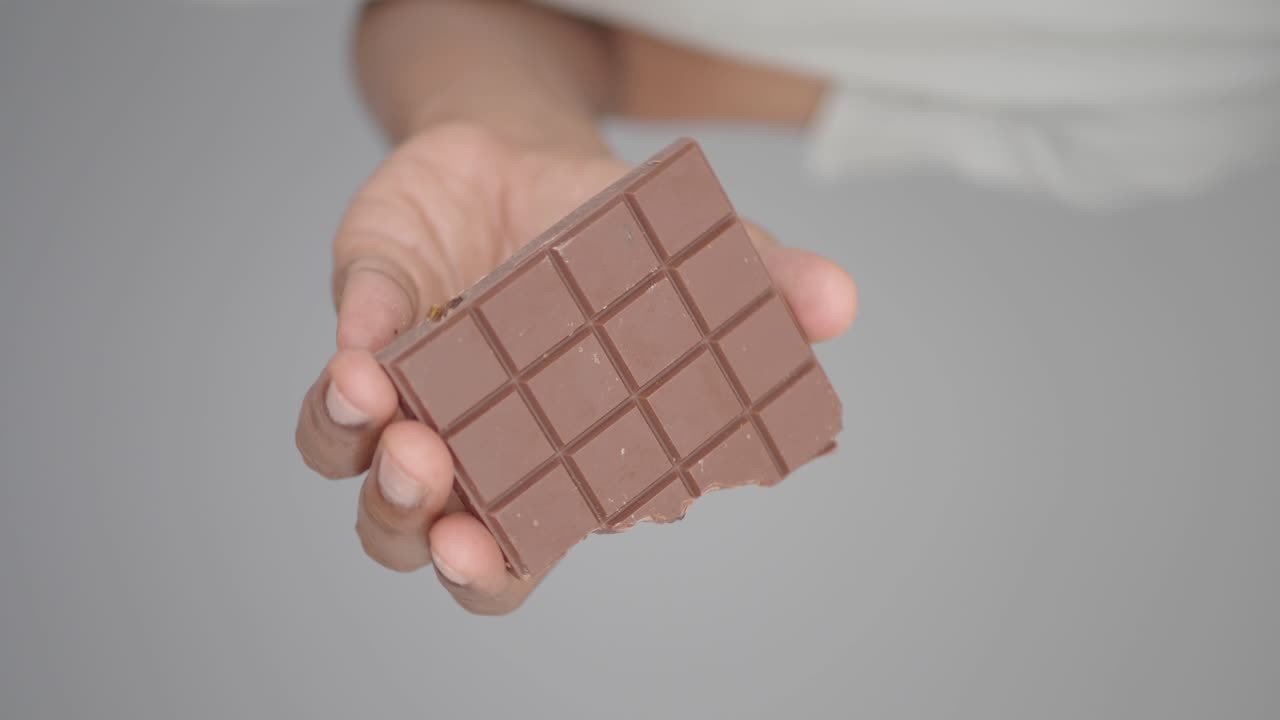 Hand holding a piece of chocolate