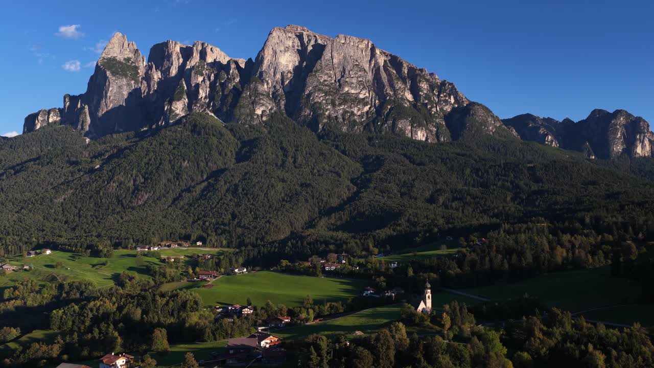 Seiser alm, Dolomites, alpine fields and small church revealing aerial drone video