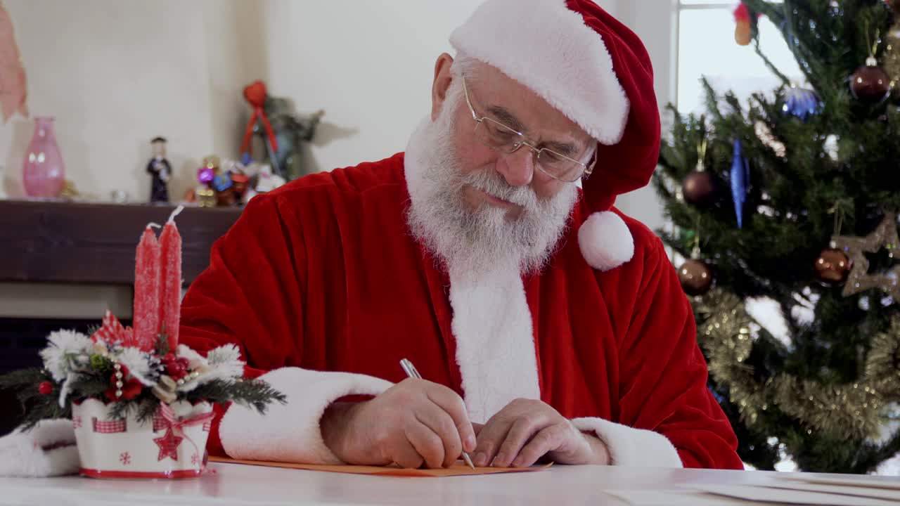 Babbo Natale scrive una lettera seduto al tavolo