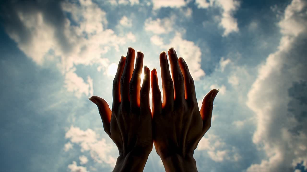 Upward angle shot of hands reaching towards the sun, symbolizing hope and aspiration
