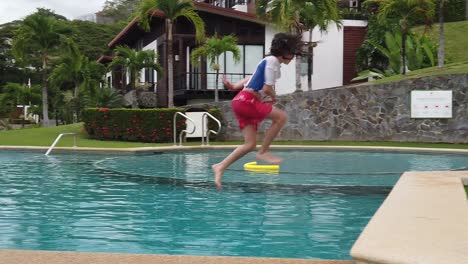 un niño activo y deportivo corriendo y saltando a una piscina