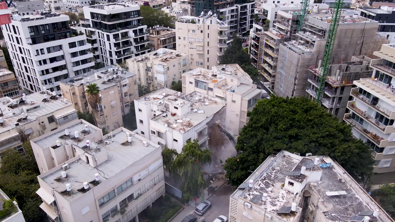 Antiguos bloques de Tel Aviv rodean un sitio impactado por un misil mientras una nueva torre se eleva cerca