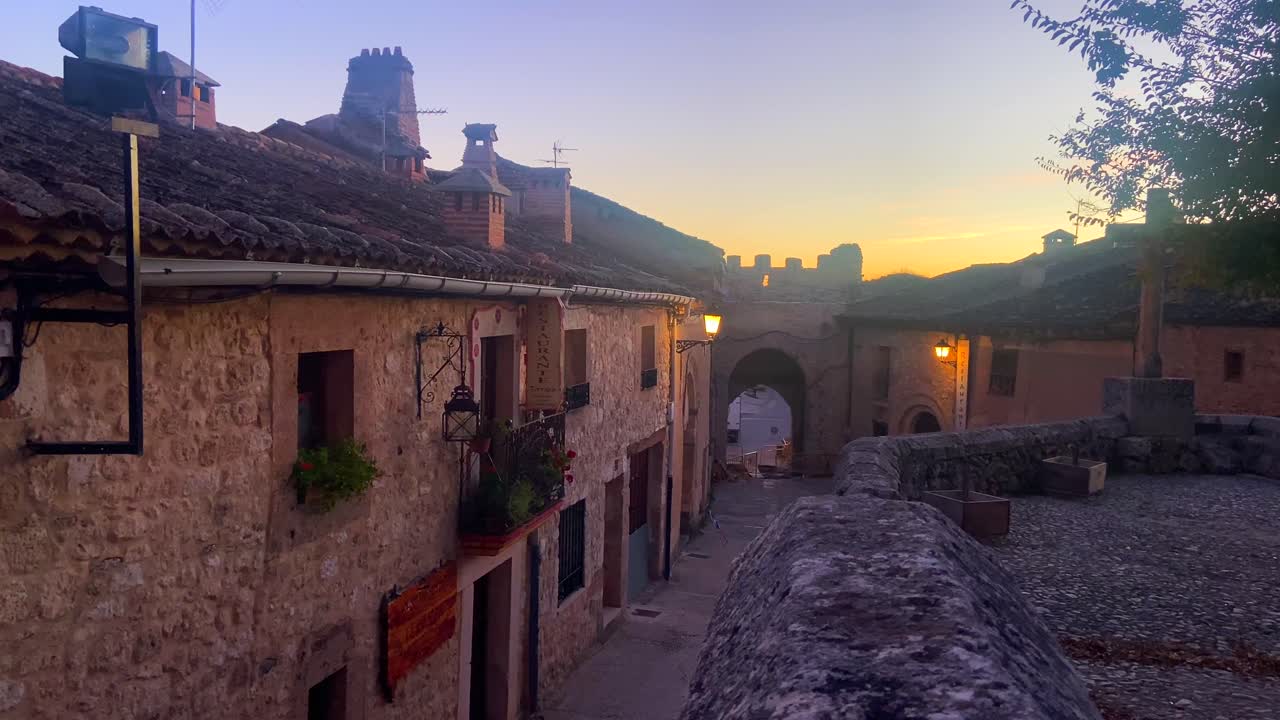 vídeo de 4k de un típico pueblo tradicional y medieval español al atardecer con la luna creciente en el cielo