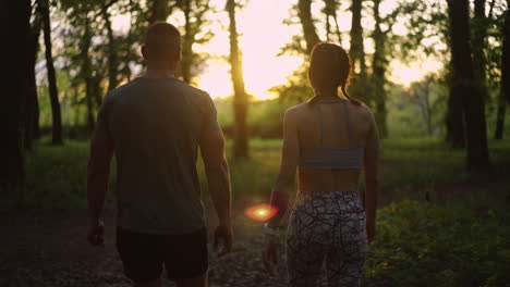 couple walking in forest at sunset