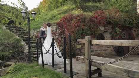 lovely newlyweds caucasian bride embracing groom in park making kiss, wedding couple family hugging