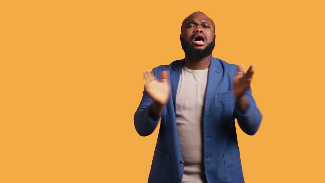 Frenetic man happily clapping hands watching sports match, studio background