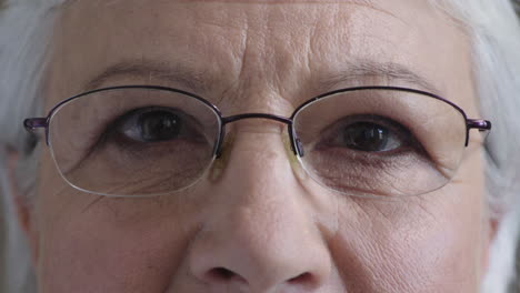 close up happy elderly woman eyes looking at camera smiling happy enjoying healthy eyesight wearing glasses