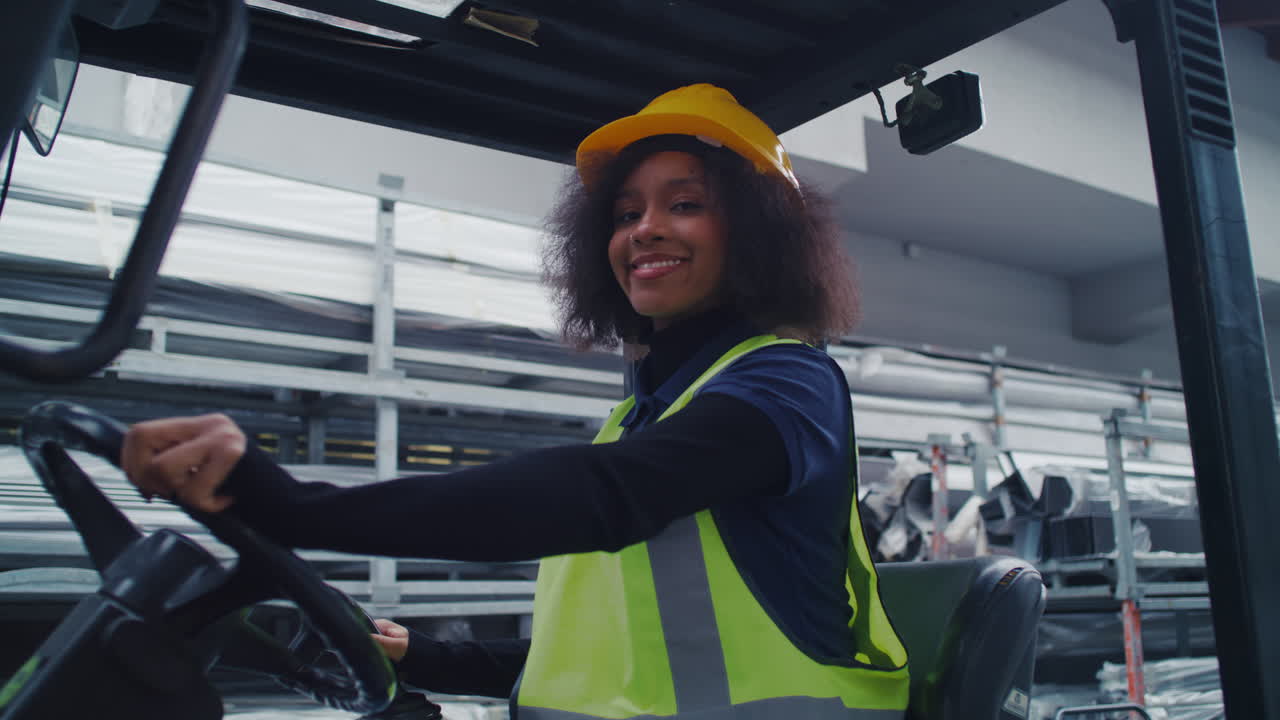 Portrait of a smiling female worker wearing protective gear a yellow hard hat and a safety vest