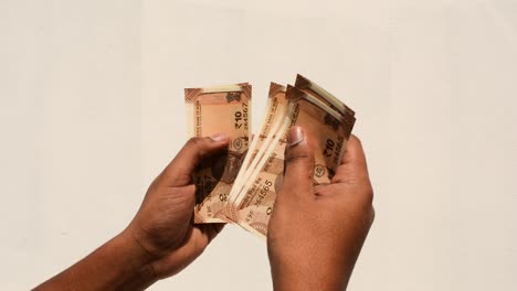 hands of a man counting new indian 10 rupee currency notes