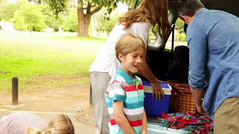 Family-unloading-their-car-for-a-camping-trip