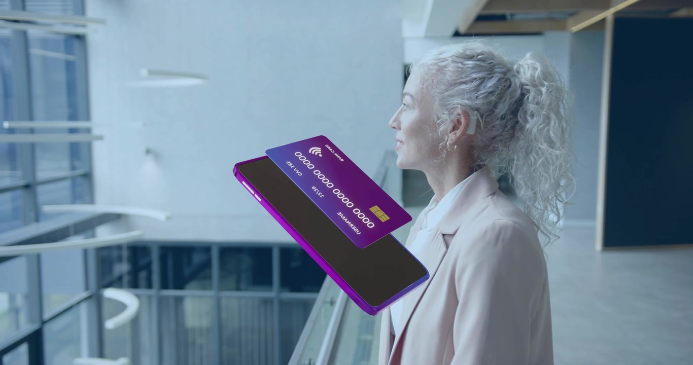 Lo smartphone che si avvicina attiva la carta di credito che ruota per il pagamento contactless mentre una donna osserva nell'atrio.
