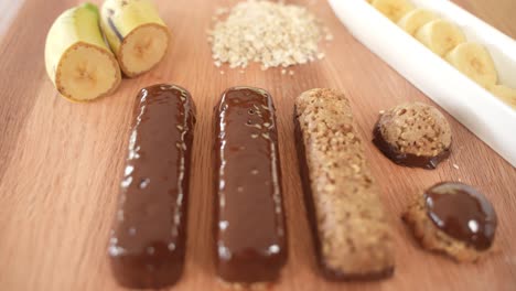 fresh oatmeal power bars with chocolate and bananas displayed on wooden table