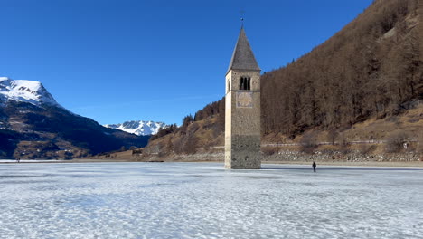 Tilt-up-shot-of-the-Tower-of-Graun-on-a-frozen-lake-on-a-sunny-day