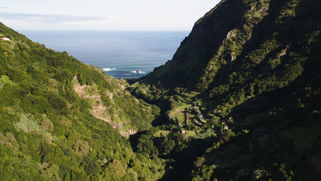 Vista aerea di una rigogliosa valle verde di montagna che conduce all'oceano