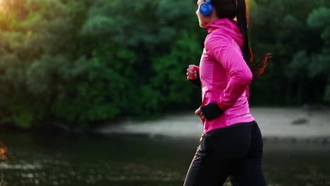 a morning jog in the park near the pond in the sunny rays of dawn, the girl is preparing to mariano and lead a healthy lifestyle