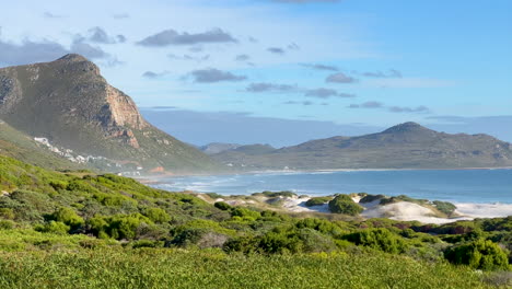 Misty-Cliffs-Cape-of-Good-Hope-most-southern-point-coastline-scenic-view-South-Africa-Cape-Town-daytime-beauty-deep-blue-aqua-lush-green-grass-summertime-pan-up-epic-landscape-slow-motion-pan-left