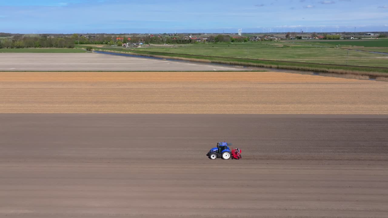 Vista aerea di trattore che coltiva il campo durante la semina primaverile nei Paesi Bassi