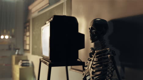 a skeleton watching television in a classroom