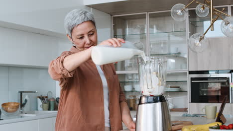 una mujer haciendo un batido.